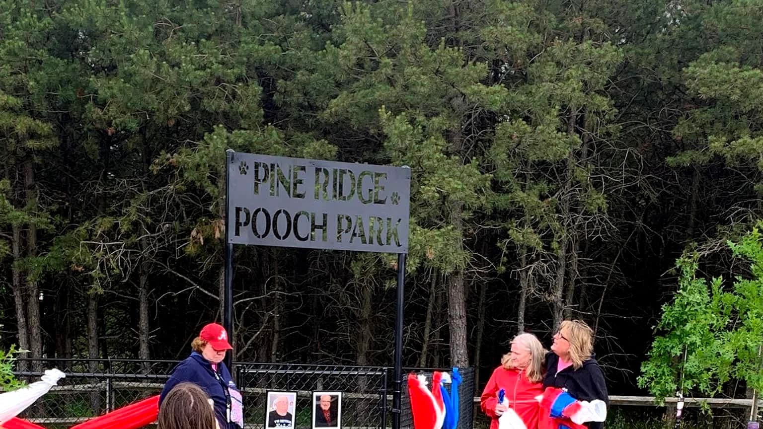 Pine Ridge Pooch Park entrance sign and fenced dog area