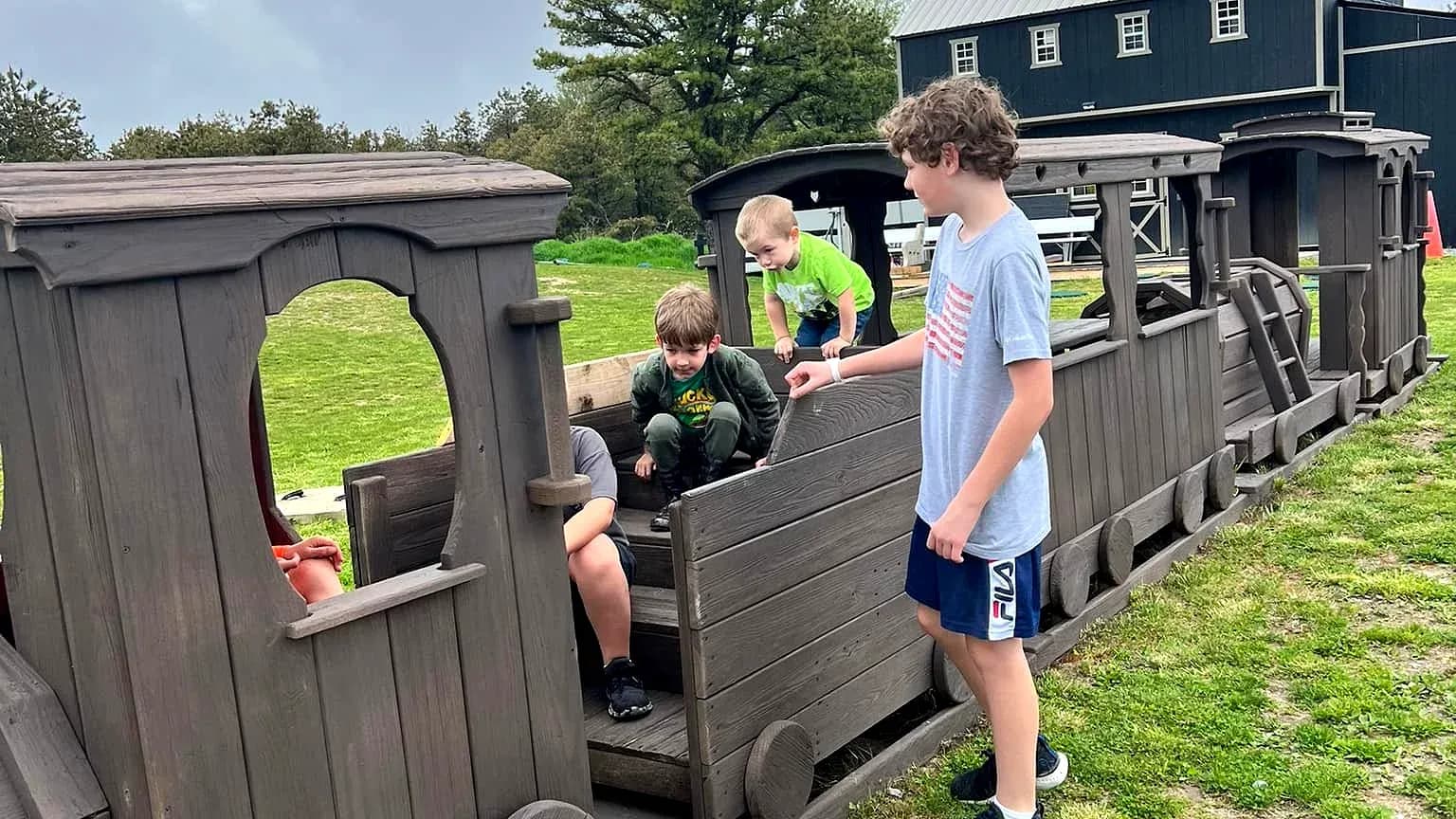 Kids playing on the wooden train playground