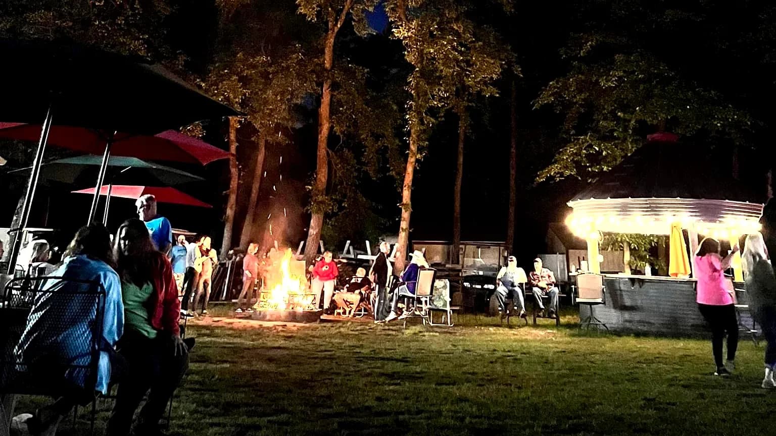 Campfire gathering with bar in background